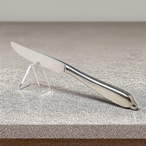 Clear acrylic knife holder with slot, holding a stainless steel knife on a kitchen counter
