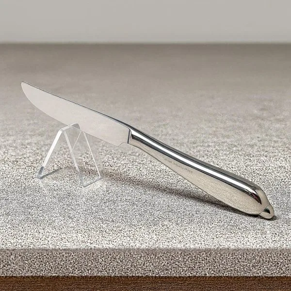 Clear acrylic knife holder with slot, holding a stainless steel knife on a kitchen counter